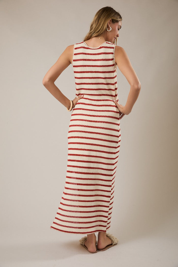 woman wearing a red and white striped sleeveless maxi dress, looking back, with a relaxed fit and side slits