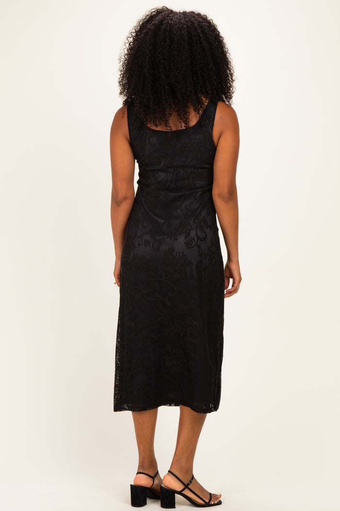 woman wearing a black sleeveless midi dress with a floral pattern and a fitted silhouette, viewed from the back
