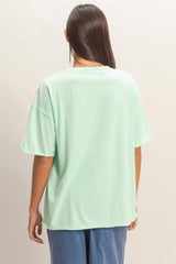 woman wearing a mint green oversized t-shirt with a relaxed fit and short sleeves