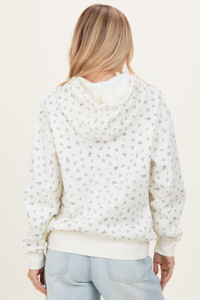 woman wearing a white hoodie with small floral prints and a relaxed fit, shown from the back