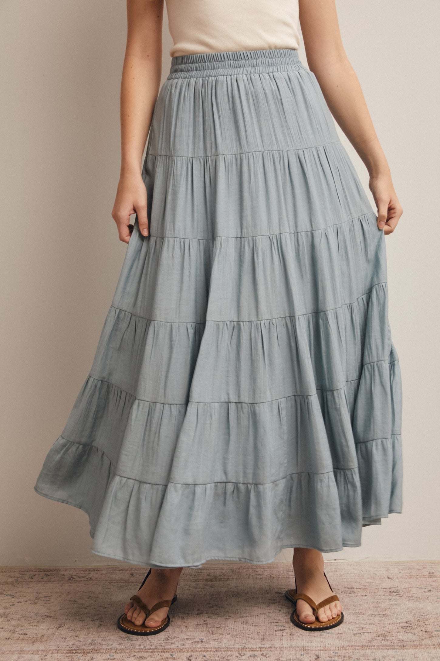 woman wearing a light blue tiered maxi skirt with an elastic waist and sandals