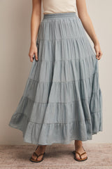 woman wearing a light blue tiered maxi skirt with an elastic waist and sandals