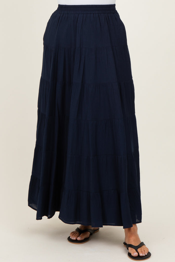 woman wearing a navy blue tiered maxi skirt with an elastic waistband and flat sandals