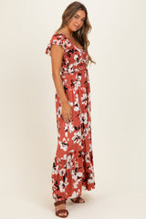 woman wearing a rust floral maxi dress with short sleeves and a flowy skirt