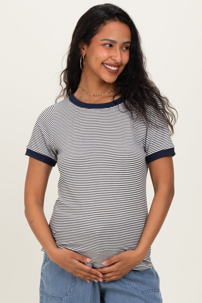 woman wearing a navy and white striped maternity top and holding her baby bump