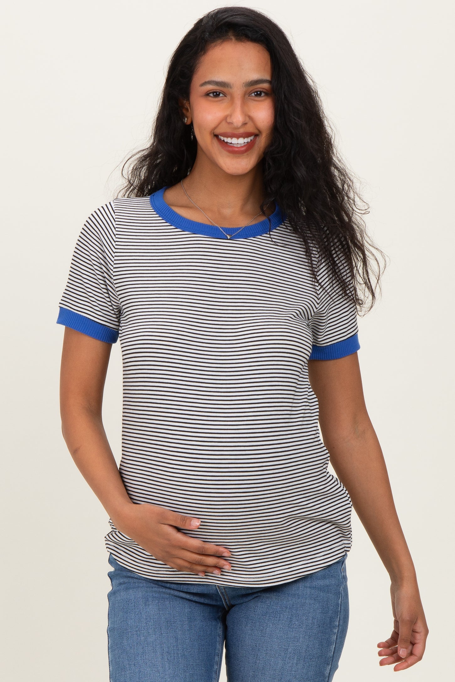 woman wearing a striped maternity t-shirt with blue sleeves and holding her baby bump