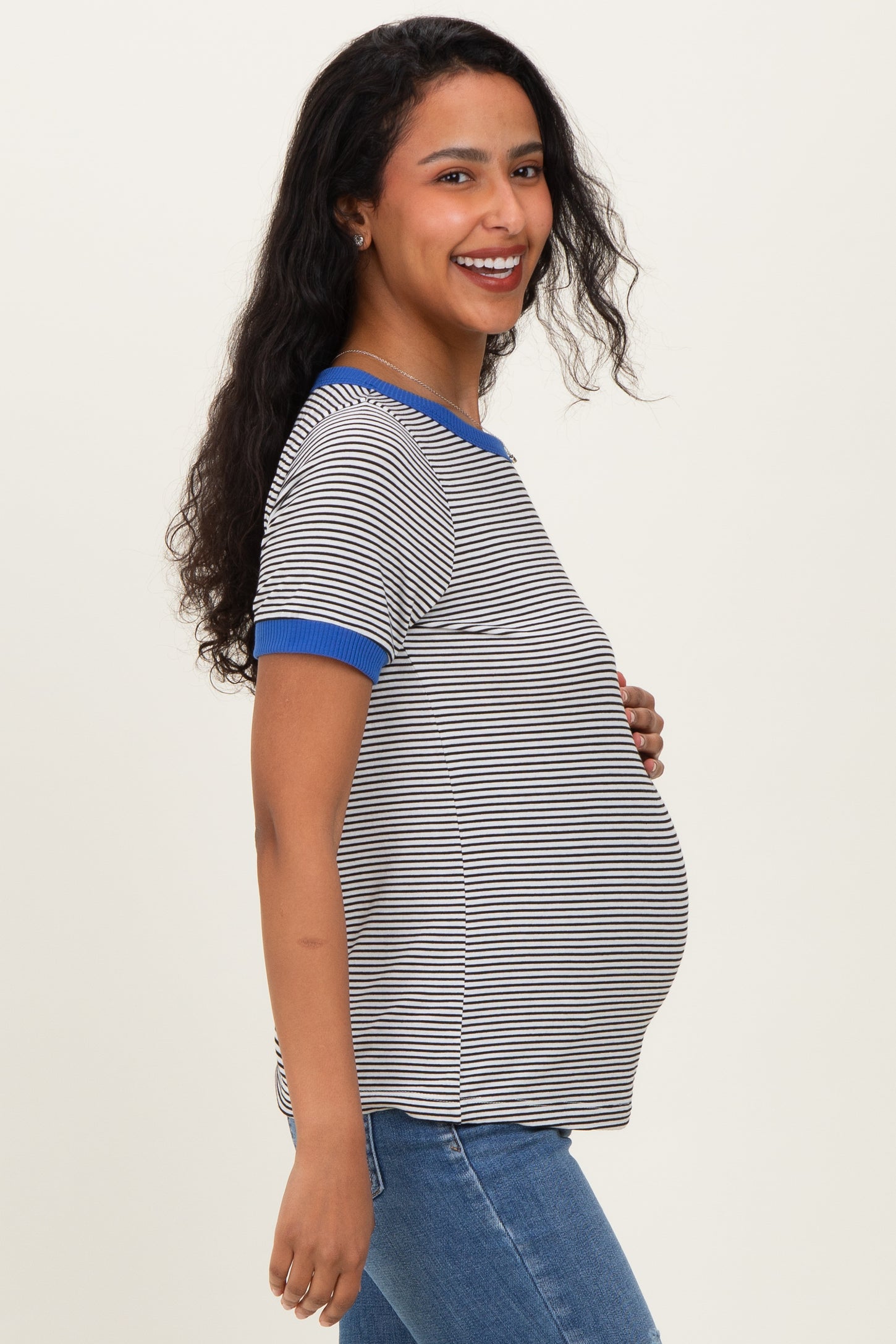 woman wearing a navy and white striped maternity top with blue trim and showing her baby bump