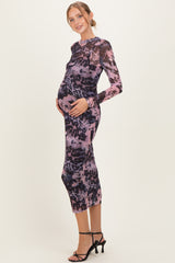 woman wearing a long sleeve purple and black leopard print maternity dress, showing her baby bump