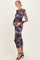 woman wearing a long sleeve purple and black leopard print maternity dress, showing her baby bump