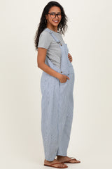 woman wearing a gray short sleeve top and blue and white striped maternity overalls, showing her baby bump