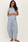 woman wearing a gray short sleeve shirt with blue and white striped maternity overalls and brown sandals