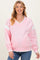 woman wearing a light pink v-neck maternity sweatshirt with white accents, smiling at the camera