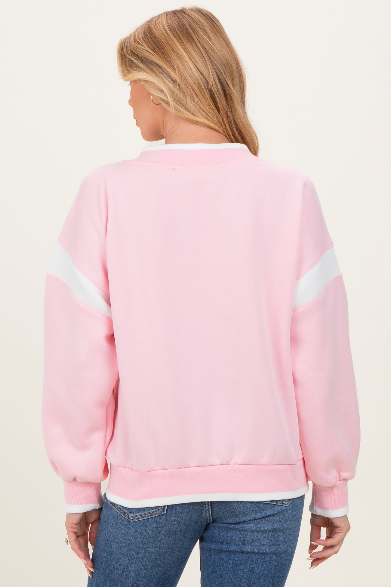 woman wearing a pink maternity sweatshirt with white stripes and balloon sleeves, viewed from the back