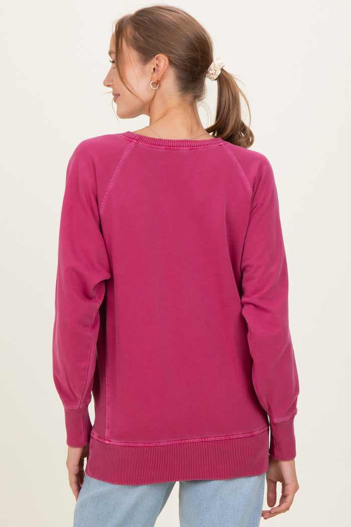 woman wearing a pink maternity sweatshirt, viewed from the back, with long sleeves and a relaxed fit