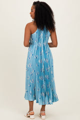 woman wearing a light blue floral midi dress with a pleated back and spaghetti straps