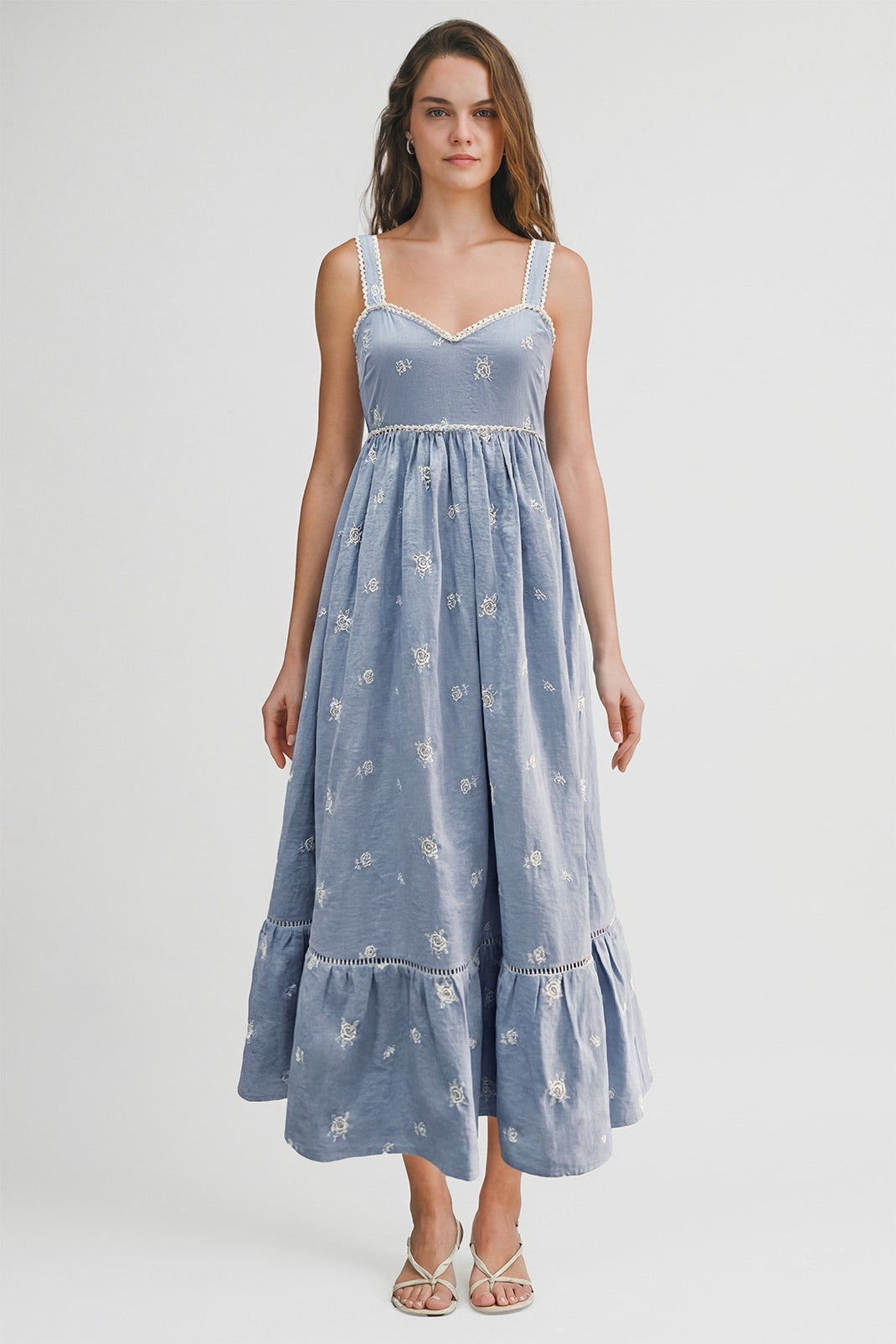 woman wearing a blue floral maxi dress with lace trim and a tiered hemline