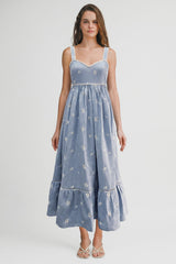 woman wearing a blue floral maxi dress with lace trim and a tiered hemline