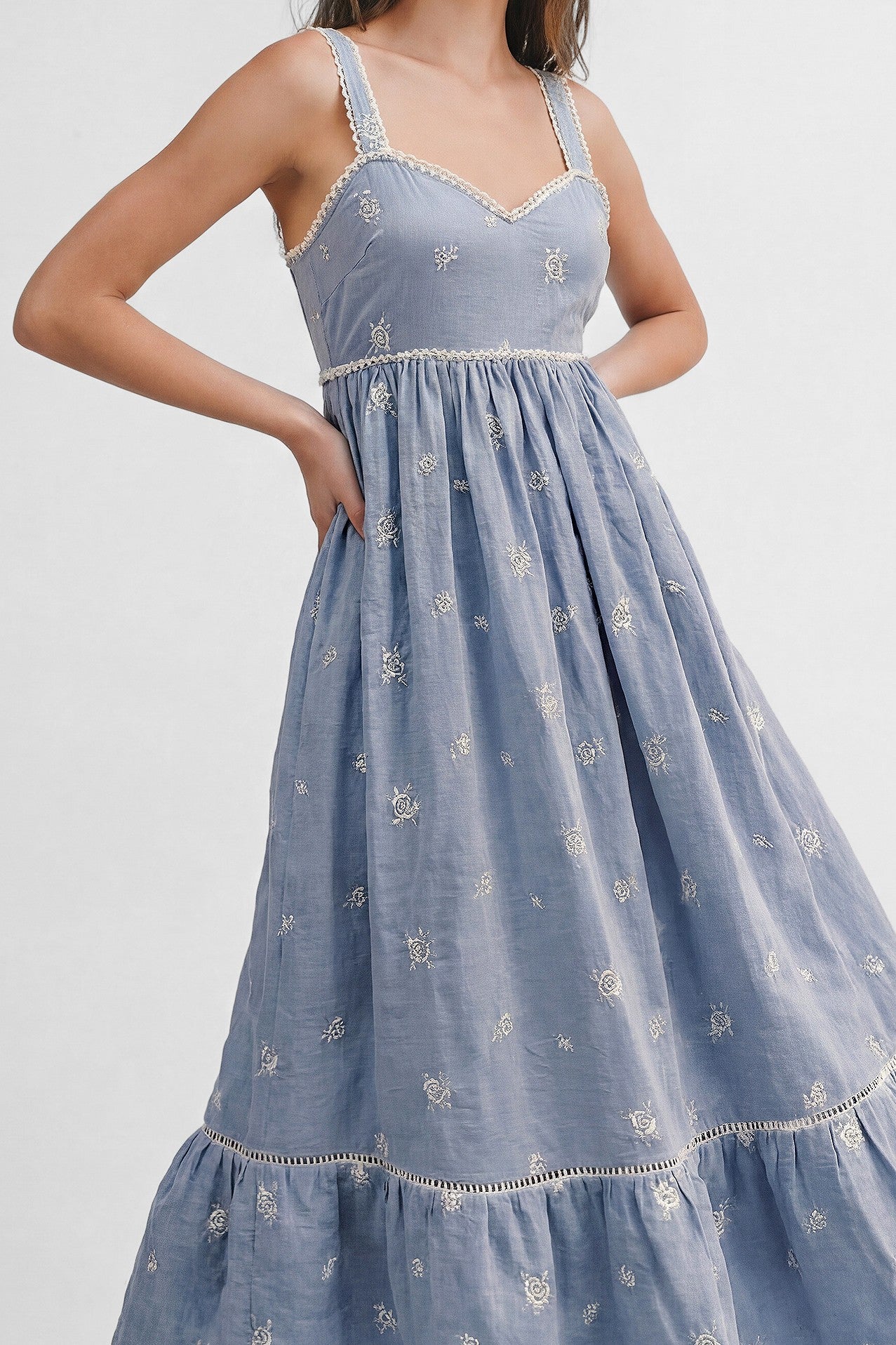 woman wearing a light blue embroidered maxi dress with a v-neck and adjustable straps