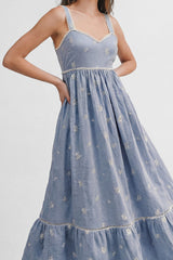 woman wearing a light blue embroidered maxi dress with a v-neck and adjustable straps