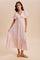 woman wearing a light pink flowy maxi dress with short puff sleeves and a tiered skirt