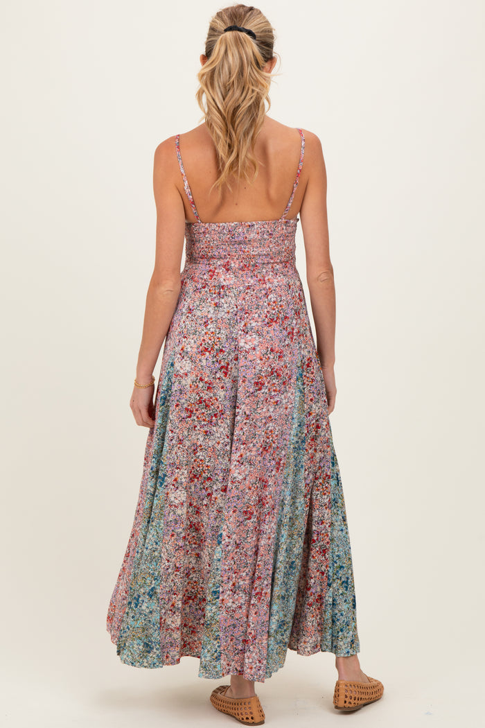 woman wearing a multicolored floral maternity maxi dress with a smocked bodice and adjustable straps, viewed from the back