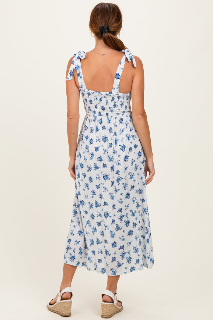 woman wearing a blue and white floral maxi dress with tie shoulder straps and a smocked back