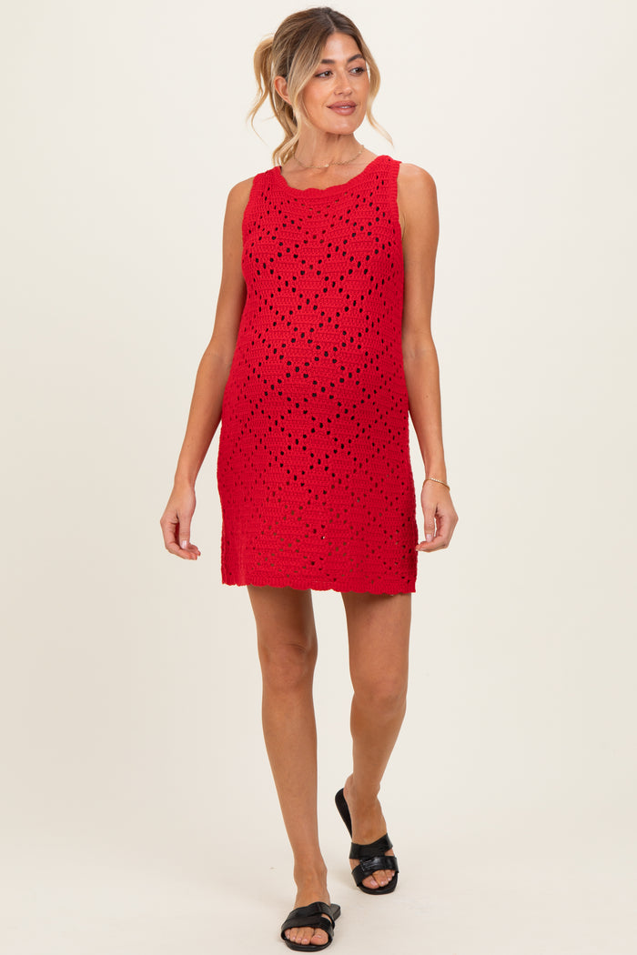 woman wearing a red sleeveless maternity dress with a perforated design and a visible baby bump