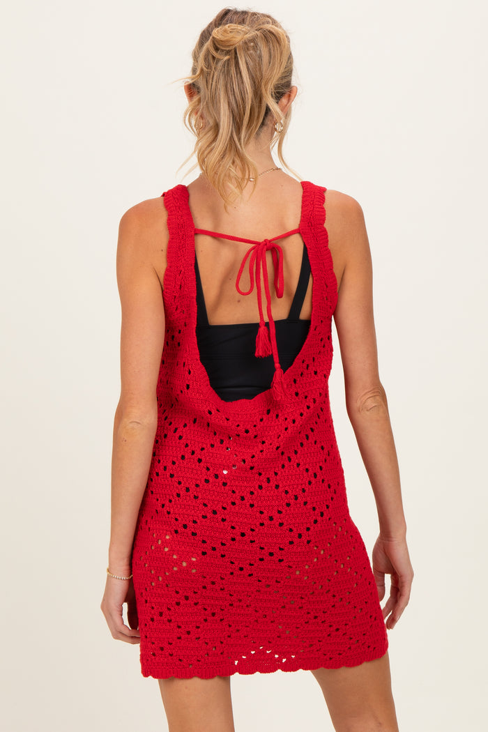 woman wearing a red open-back crochet maternity dress with a back tie detail