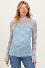 woman wearing a light blue lace maternity top with long sleeves and a scoop neckline, styled over a cami