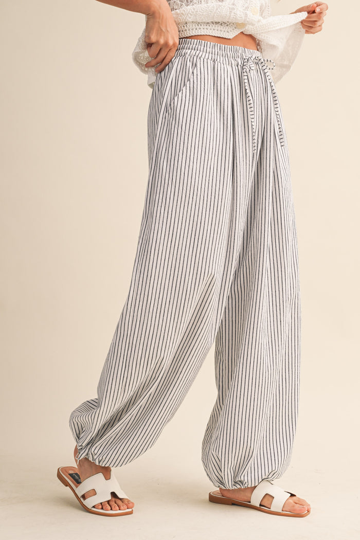 woman wearing white and gray striped wide-leg pants with an elastic waistband and a relaxed fit