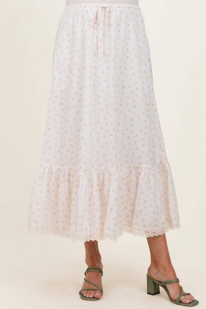 woman wearing a light pink maternity skirt with floral print and ruffle hem