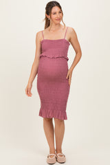 woman wearing a mauve maternity dress with smocked detailing and ruffle hem, showcasing her baby bump