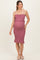 woman wearing a mauve maternity dress with smocked detailing and ruffle hem, showcasing her baby bump