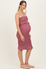 woman wearing a dusty mauve maternity dress with ruffle details and a visible baby bump