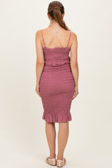 woman wearing a dusty rose maternity dress with smocked detailing and ruffled hem, seen from the back