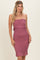 woman wearing a dusty rose smocked midi dress with ruffle details and spaghetti straps