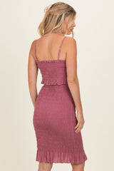 woman wearing a smocked midi dress in dusty rose with ruffle hem and thin straps, shown from the back