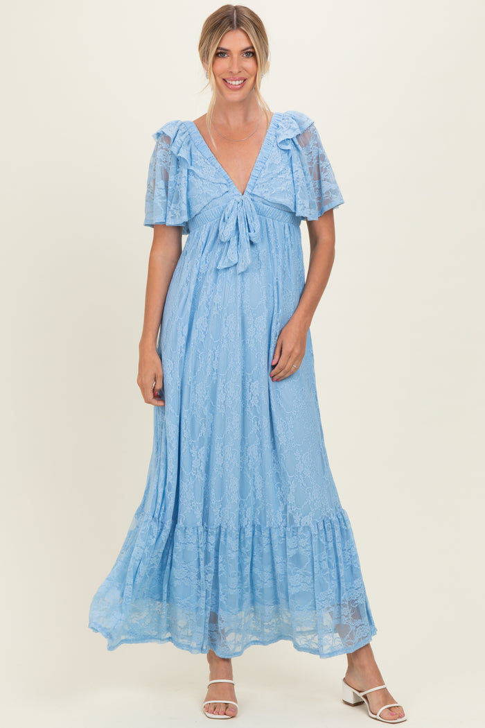 woman wearing a light blue lace maxi dress with short ruffle sleeves and a bow detail at the neckline