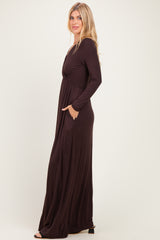 woman wearing a chocolate brown long sleeve maxi dress with a cinched waist and side pockets