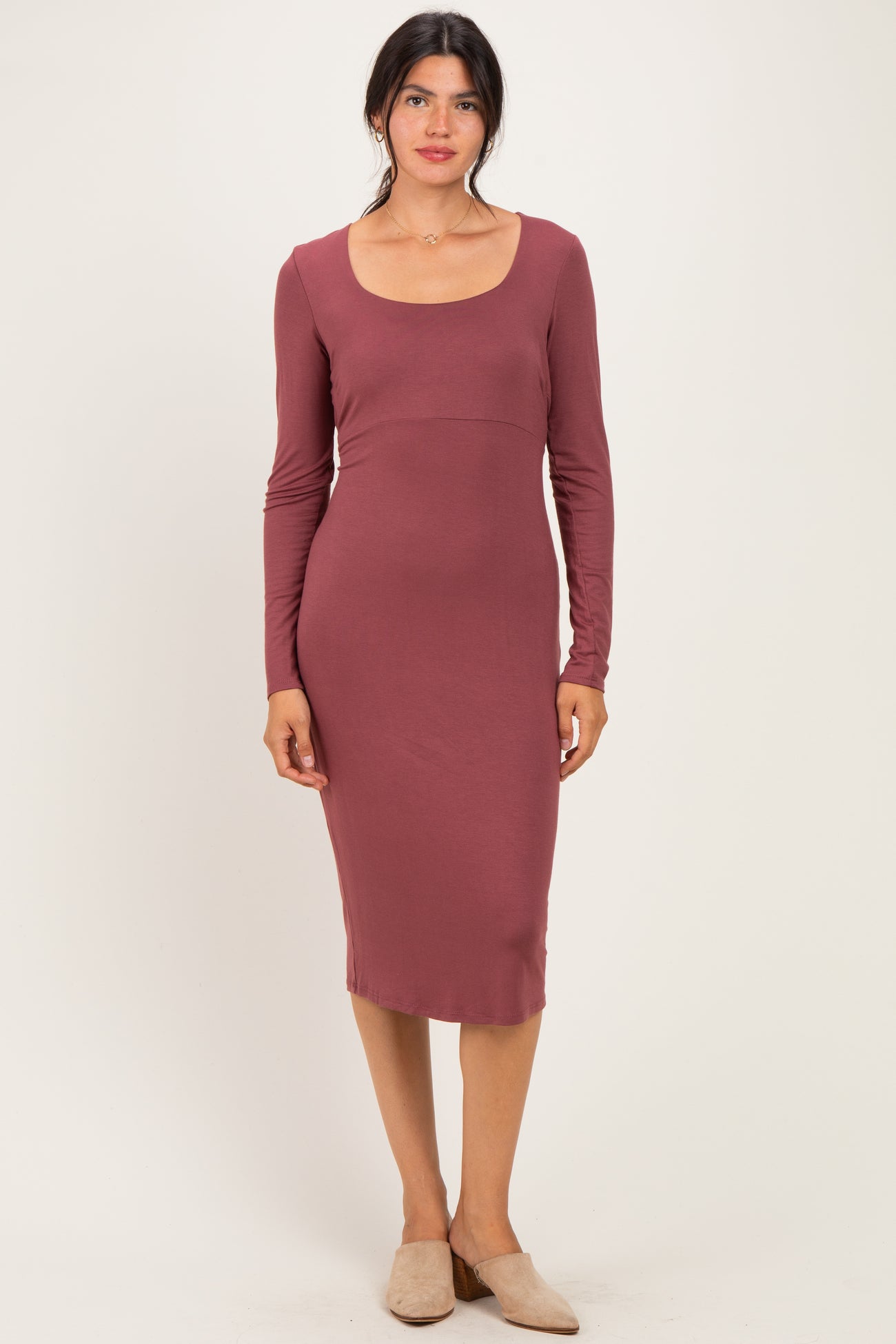 woman wearing a mauve long sleeve fitted midi dress with a scoop neckline