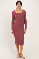 woman wearing a mauve long sleeve fitted midi dress with a scoop neckline