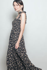 woman wearing a navy blue floral maxi dress with tie straps and a smocked bodice