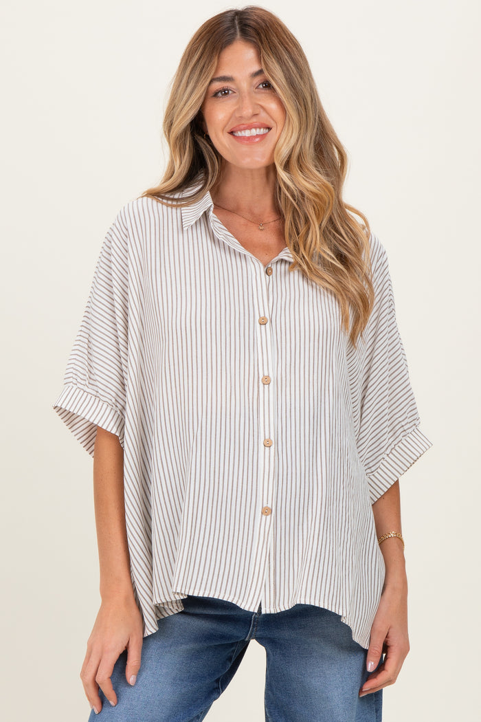 woman wearing a beige and white striped maternity shirt with short sleeves and buttons, paired with blue jeans