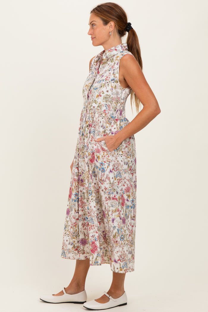 woman wearing a sleeveless floral print midi dress with a collar and pockets