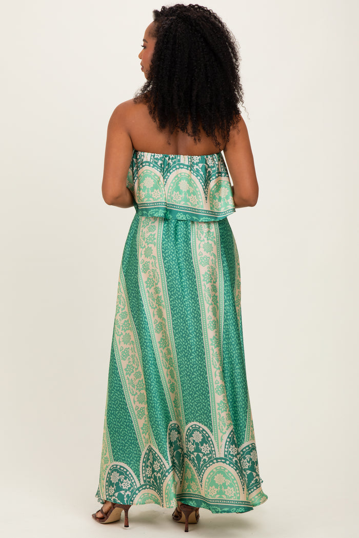 woman wearing a green patterned maxi dress with a strapless design and ruffled bodice, shown from the back