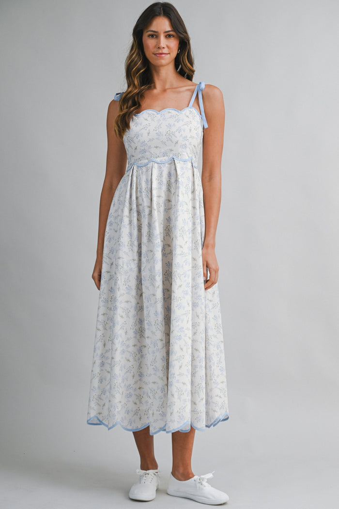 woman wearing a floral print midi dress with blue accents and tie straps