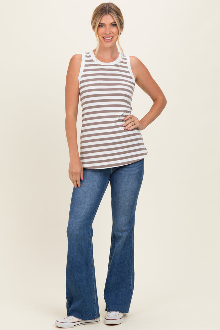 woman wearing a brown and white striped sleeveless top with blue flared jeans