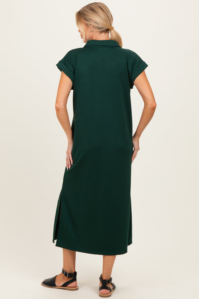 woman wearing a dark green maternity dress with short sleeves and side slits, showing the back view