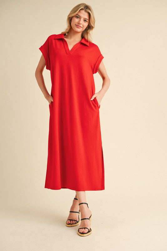 woman wearing a red short sleeve maxi dress with a collared neckline and side pockets