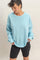 woman wearing a light blue oversized sweatshirt paired with black bike shorts